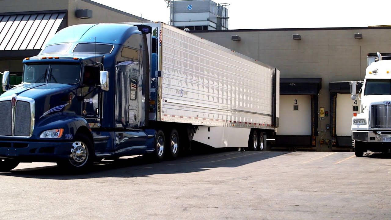 Blue and White Semi Tractor Trailer trucks and their distribution center. Shippers - Freight Brokers